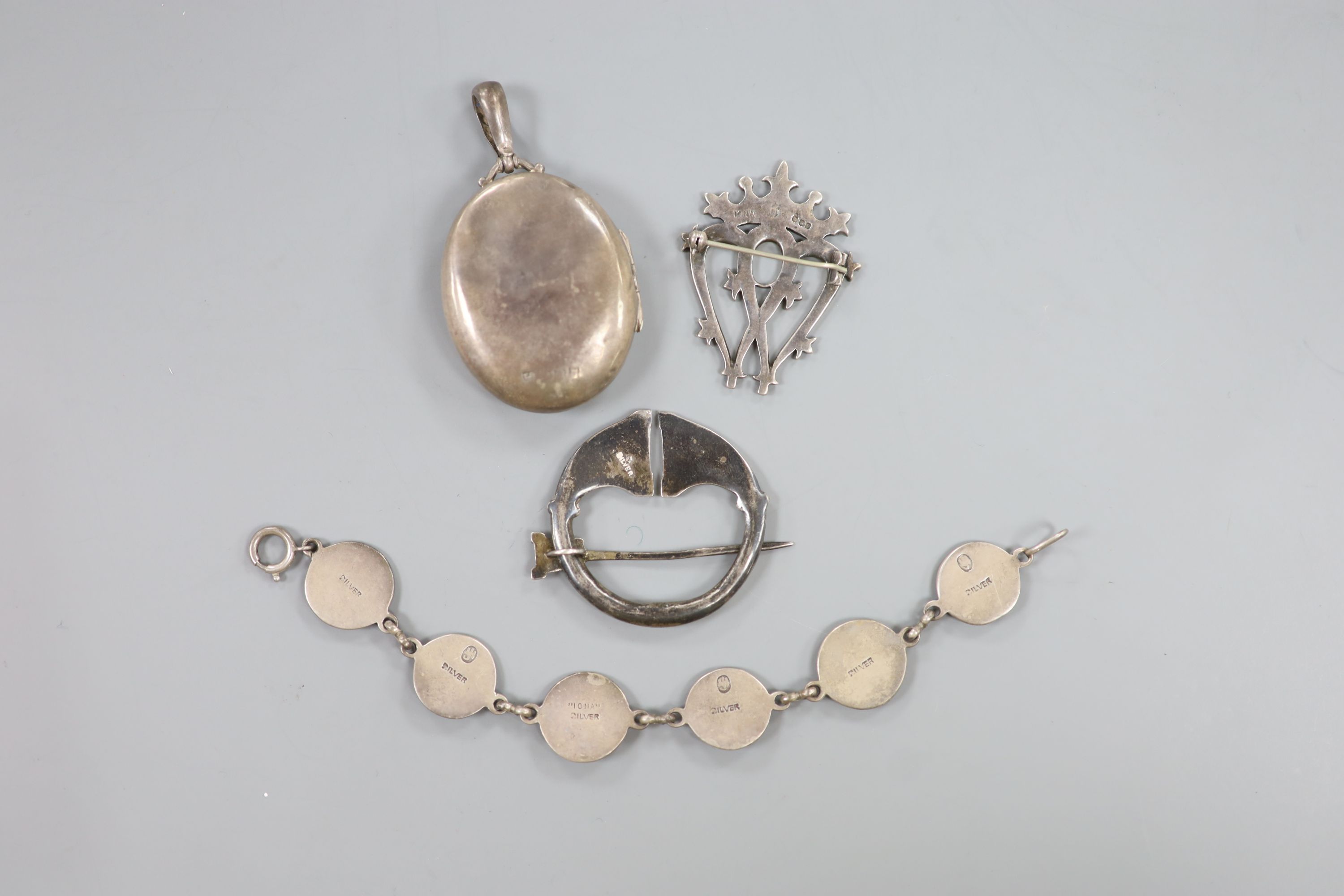 A Scottish silver Iona coronet mounted brooch, 44mm, a white metal Celtic brooch , a silver locket and a white metal bracelet.